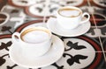 Cups with coffee on tiled table