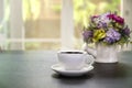 Cups of coffee and vase with beautiful flower bouquet  on table in coffee shop background Royalty Free Stock Photo