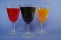 3 Cups of colorful cocktails mimosa and red wine set un on a blue background Royalty Free Stock Photo