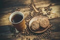 Cups and cups with coffee, coffee grains and gingerbread cookies nearby for refreshments in warm home colors