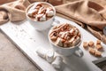Cups of delicious cocoa drink with marshmallows on wooden board Royalty Free Stock Photo