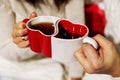 Cups in the form of hearts in the hands of a man and a woman