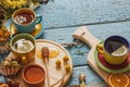 Cups with herb tea and pieces of lemon, dried herbs and different decorations