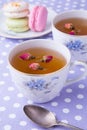 Cups of herbal tea with macaroons on polka dot towel