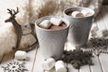 Cups of hot cocoa with marshmallows and Christmas decorations on wooden table Royalty Free Stock Photo