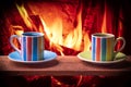 Cups of hot drink in front of warm fireplace. Holiday Christmas concept. Royalty Free Stock Photo