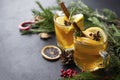 2 cups of hot tea with slices of Apple and lemon, cinnamon, star anise, rosemary sprigs on a background of fir branches on a black Royalty Free Stock Photo