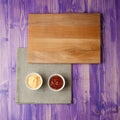 Cups with ketchup and cheese on napkin made from canvas on a wooden table