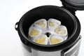 Cups of pineapple yogurt in multi cooker on white, closeup Royalty Free Stock Photo