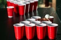 Cups and plastic ball for beer pong game on table