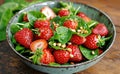 cups of strawberries, assorted greens and pine nuts