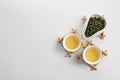 Cups of Tie Guan Yin and chahe with tea leaves on white background