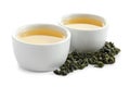 Cups of Tie Guan Yin oolong and tea leaves on white Royalty Free Stock Photo