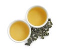 Cups of Tie Guan Yin oolong and tea leaves on white background Royalty Free Stock Photo
