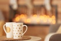 Cups on white table in decorated living room Royalty Free Stock Photo