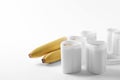 Cups of yogurt with bananas on white background Royalty Free Stock Photo