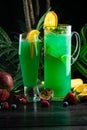 Curacao lemonade in a glass and jug decorated with an orange slice