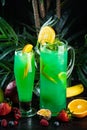 Curacao lemonade in a glass and jug decorated with an orange slice