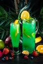 Curacao lemonade in a glass and jug decorated with an orange slice