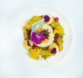 Curd dessert with ice cream decorated with chocolate and flowers. Yellow. On a white toiler. view from above.