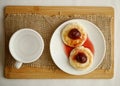 Curd pancake on a white plate with strawberry jam next to a cup. top view Royalty Free Stock Photo