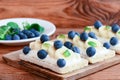 Cream cheese banana berries sandwiches. Vegetarian cracker bread with toppings on wooden board Royalty Free Stock Photo