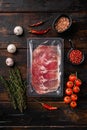 Cured ham jamon vacuum plastic pack, on old dark  wooden table background, top view flat lay Royalty Free Stock Photo