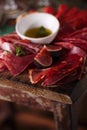 Cured Meat and olive oil on textured old wooden stool Royalty Free Stock Photo