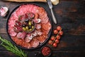 Cured meat platter of traditional spanish tapas. Chorizo, salchichon, longaniza and fuet on dark wooden background, topview with