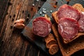 Cured meat on a slate plate. Cold cuts, bread and spices on a wooden table. Products for a sandwich Royalty Free Stock Photo