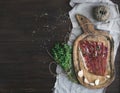 Cured pork meat prosciutto on a rustic woodem board with garli Royalty Free Stock Photo