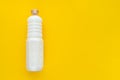 cured white coconut oil in a bottle on a yellow background.