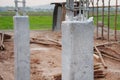 Clear plastic covers concrete columns to prevent water loss in concrete on the construction site. The concrete curing process