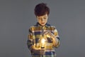 Boy touching glowing lightbulb lamp in hand stand on studio copy space