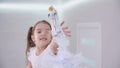 Sweet little girl is eager to reach an angel decoration on the top of christmas tree.