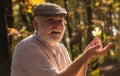 Curiosity to botany. Explore world around. Pensioner hiking in forest on sunny autumn day. Man enjoy autumn nature. See Royalty Free Stock Photo