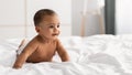 Curious adorable little African American kid lying on bed Royalty Free Stock Photo