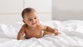 Curious adorable little African American kid lying on bed Royalty Free Stock Photo