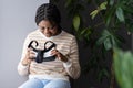 Curious afro lady holding futuristic innovative VR glasses, testing virtual reality headset at first