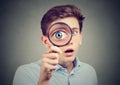 Curious amazed man looking through a magnifying glass Royalty Free Stock Photo