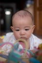 Curious Asian infant baby boy lie on the stomach or prone playing and looking at toy