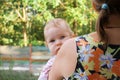 Curious baby babe peeping from behind the shoulder of the mother Royalty Free Stock Photo