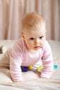 Curious baby girl crawling on bed, closeup shot Royalty Free Stock Photo