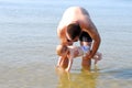 Curious baby girl with her father touching the sea Royalty Free Stock Photo