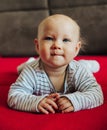 Curious baby girl lying on bed, smiling front view Royalty Free Stock Photo