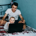 Curious baby girl using laptop sitting at home bed Royalty Free Stock Photo