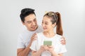 Curious boyfriend is spying his lovers smartphone. They are wearing casual shirts, standing isolated on white background Royalty Free Stock Photo