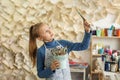 Curious Child Engaged in Artistic Exploration. Child Girl Holding Paint Brushes in Art Studio Royalty Free Stock Photo