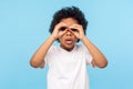 Curious child exploring world. Portrait of inquisitive nosy little curly boy looking through fingers shaped like binoculars