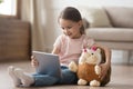 Curious child girl having fun using digital tablet embracing toy